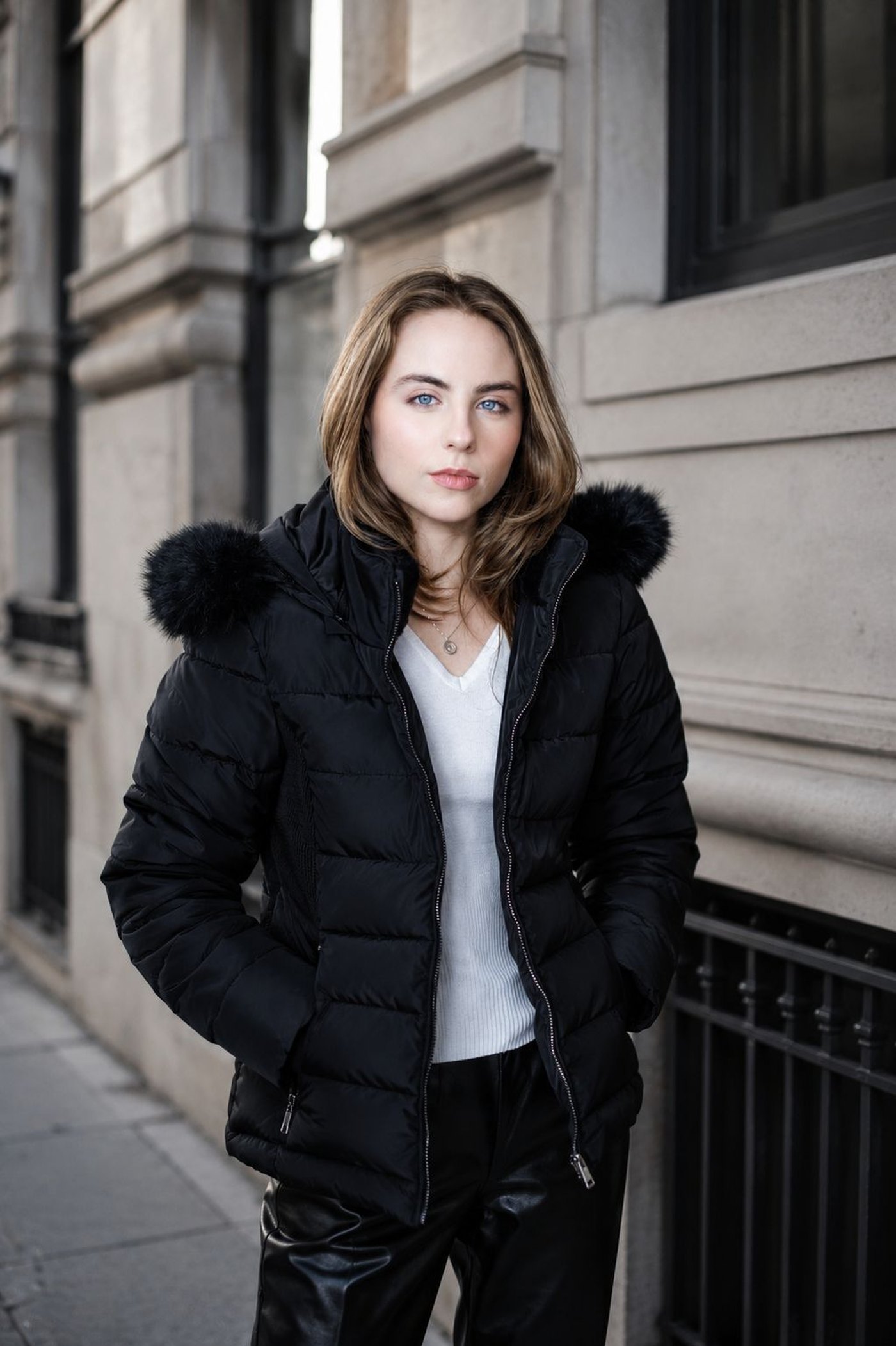 Modelo em puffer preta com capuz de pelo em rua urbana